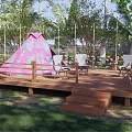 Garden Landscape Featuring Pink Tent Wooden Deck Chairs Trees And String Lights On Grass