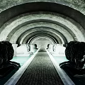 Arched Tunnel With Lion Statues Along Stone Brick Pathway And End Light