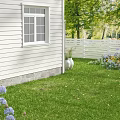 Beautiful Garden With White House Window White Fence Green Lawn And Purple Flowers