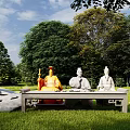 Ancient Figure Sculptures In Outdoor Grassland With Green Trees And Stone Table