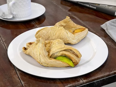 Flaky Puff Pastries On White Plate Over Wooden Table With White Cup Saucer And Cloth 3d model