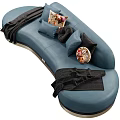 Stylish Blue Irregular Shaped Sofa With Decorative Pillows And Black Throw Blanket