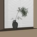 Dark Clay Vase With Bamboo Leaves On Light Colored Surface By White Blinds