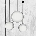 Three Spherical Beige Paper Pendant Lights with Warm Glow against Grey Wall Background