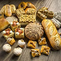 Assorted Freshly Baked Breads And Pastries On Wooden Table With Honey And Nuts