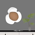 Modern Wall Lamp with White Petal Shape Gold Center and Green Plant in Living Room