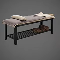 Massage Bed with Black Frame Gray Beige Blanket Pillows and Lower Shelf Stacked Towels