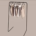 Black Metal Clothes Display Rack With Light Colored Tank Tops Hanging