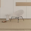 White Fabric Lounge Chair With Black Metal Legs And Round Side Table On Beige Carpet