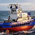 Janisco Ship Sailing On Ocean With Blue White Red Hull And Upper Structure