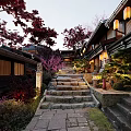 Traditional Commercial Street Featuring Stone Steps Lanterns Red Maple Trees And Illuminated Evening Ambiance
