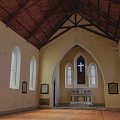 Traditional Church Building With Steeple Tower Brown Exterior Gray Roof Round Window And Arched Doorway