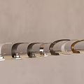Multiple Modern Faucets In Various Colors And Designs On Light Countertop With Gray Wall