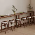 Warm Interior Featuring Long Wooden Bar Counter Green Plants Glassware And Bar Stools