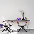 Black Office Desk Against White Wall With Laptop Books Vase Dried Branches Plant Red Chairs