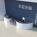 Modern Marble Reception Desk with Blue Background Wall Welcome Sign and Receptionist Standing