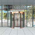 Modern Glass Building Entrance With Bronze Revolving Door And Stone Floor