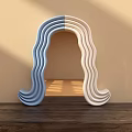 Modern Sculptural Wavy Two Tone Blue And White Mirror On Wooden Surface With Light Shadows