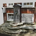 Stone Fountain With Stepped Base Against Brick Wall And White Framed Windows
