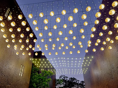 Round Shaped Decorative Lights Hanging Above Outdoor Space With Buildings And Green Plants 3d model