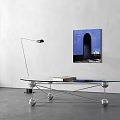 Glass Coffee Table With Metal Base Spherical Accents And Books Near Blue Wall Art