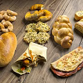 Assorted Fresh Baked Bread and Savory Food Items Displayed on Rustic Wooden Table