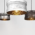 Three Modern Pendant Lights With Wavy Metal Shades And Warm Illumination