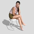 A Woman Sitting On White Stool Wearing Pink Top Green Shorts And Beige High Heels