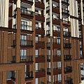 Modern High Rise Apartment Building With Brown Exterior And Balconies On Multiple Floors