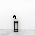 Black Plate Decoration Display On Small Black Table With Golden Base Against White Background Wall