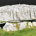 Outdoor Stone Structure With Large Top Slab And Supporting Stones On Green Grass
