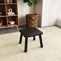 Black Wooden Stool Placed On Woven Rug Near Wicker Basket And Wooden Shelf In Interior