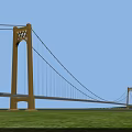 Yellow Suspension Bridge With Tall Towers Against Blue Sky And Green Grass