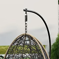 Two Rattan Hanging Outdoor Chairs With White Cushions Curved Metal Stand In Garden Lawn
