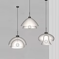Three Transparent And Brown Glass Pendant Lights Hanging On White Wall With Light Glow