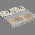Cozy Bed with Black and White Floral Bedding Pillows and Beige Blanket