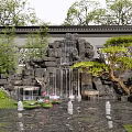 Traditional Rockery with Waterfall and Lotus Pond Surrounded by Trees and Plants