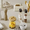 Spice Bottles and Pepper Grinders with Cheese Jar Herbs and Towel on Kitchen Countertop