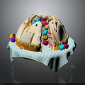Round Dome Shaped Cake With White Frosting And Colorful Decorations On Blue White Checkered Napkin