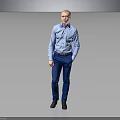 Man In Blue Shirt And Blue Pants Standing With Hands In Pockets Against Gray Background
