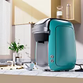 Teal Coffee Maker Kitchen Appliance On Modern Marble Countertop With Cabinets And Window Plant