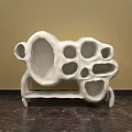White Abstract Sculpture Carving with Hollow Holes and Textured Surface in Indoor Setting