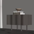 Modern Nightstand with Curved Front Design and Stack of Books with Decorative Bowl