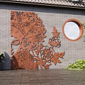 Chinese Courtyard Carved Wall Art with Circular Window and Parent Child Pointing Near Green Plants