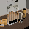 Stacked Brown Paper Cups With Small Boxes Cylindrical Canisters And Black Lids On Table