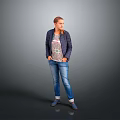 Woman in Dark Jacket and Patterned T-Shirt with Blue Jeans on Gray Background