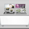 White Skincare Display Counter With Advertising Screens And Green Plants