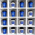 Blue and White Cups With Blue Logo Black Lids Neatly Arranged on White Grid Shelves