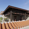 Outdoor Patio Cover With Red Tile Roof Shading Seating Area Among Green Trees
