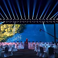 Elegant Banquet Hall With Stage Lighting White Tables And Floral Decor